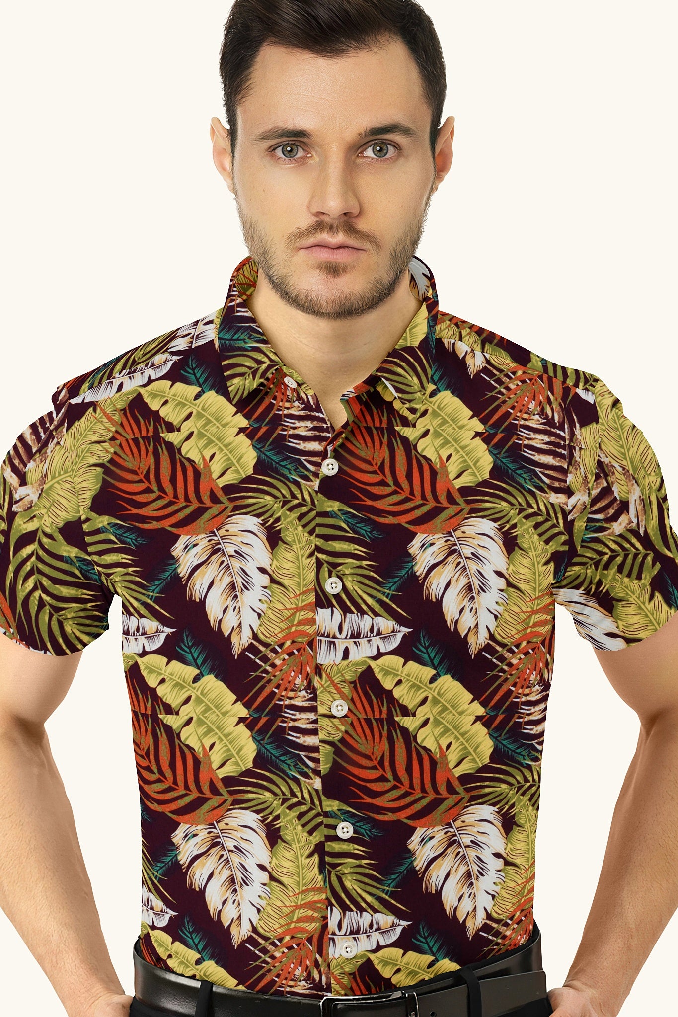 A man wearing a multicolored shirt with a monstera leaf pattern.